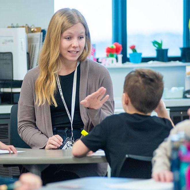  Young female teacher working on lesson with a young student.